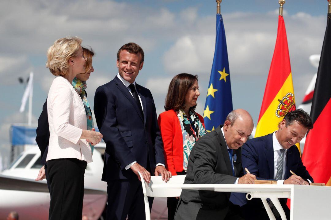 El presidente galo, Emmanuel Macron (3-izq); las ministras de Defensa española, Margarita Robles (3-dcha); gala, Florence Parly (2-izq); y alemana, Ursula von der Leyen (izq), asisten a la ceremonia de firma por parte del presidente y consejero delegado de Dassault Aviation, 