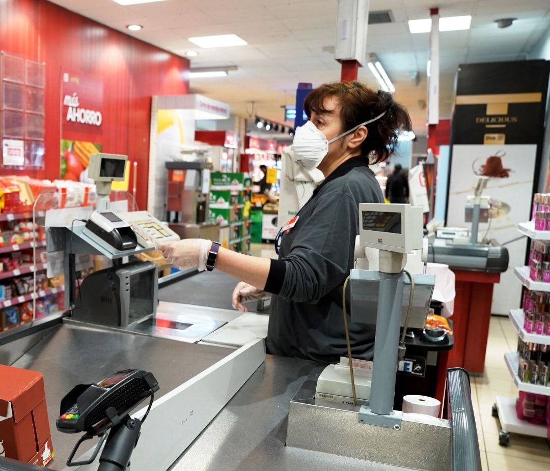 Empleado de un supermercado con mascarilla por el coronavirus