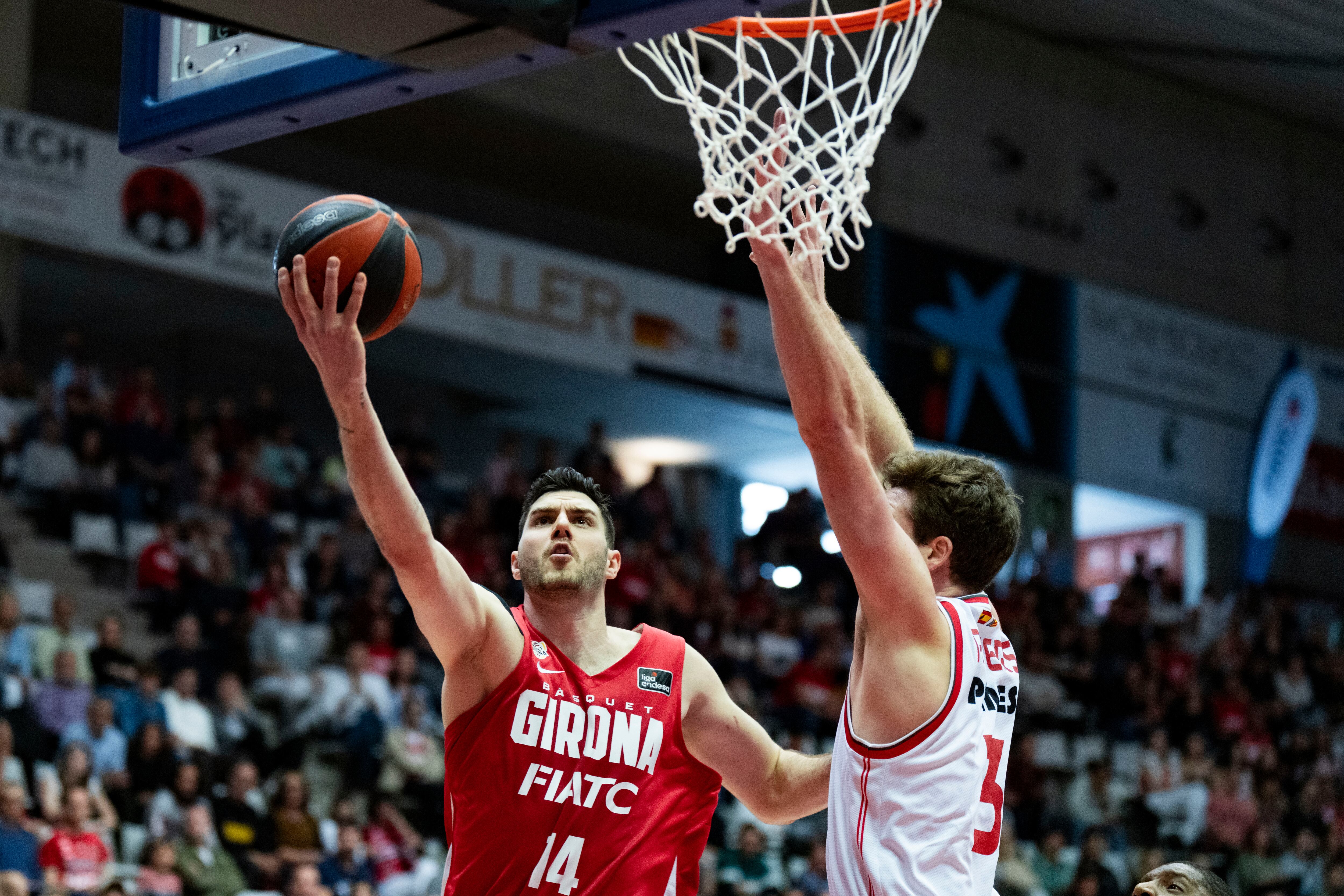 GIRONA, 17/03/2024.- El pívot húngaro del Basquet Girona Gyorgy Goloman (I) entra a canasta ante el ala-pívot americano del Valencia Basket Nate Reuvers durante el encuentro correspondiente a la fase regular de la Liga Endesa disputado hoy domingo en el pabellón de Fontajau de Girona. EFE/Siu Wu