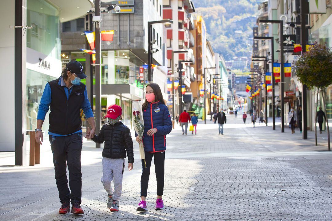 Una família passeja per l'eix comercial central. A partir de l'1 de juny les botigues tornaran a obrir després de la crisi sanitària del coronavirus.