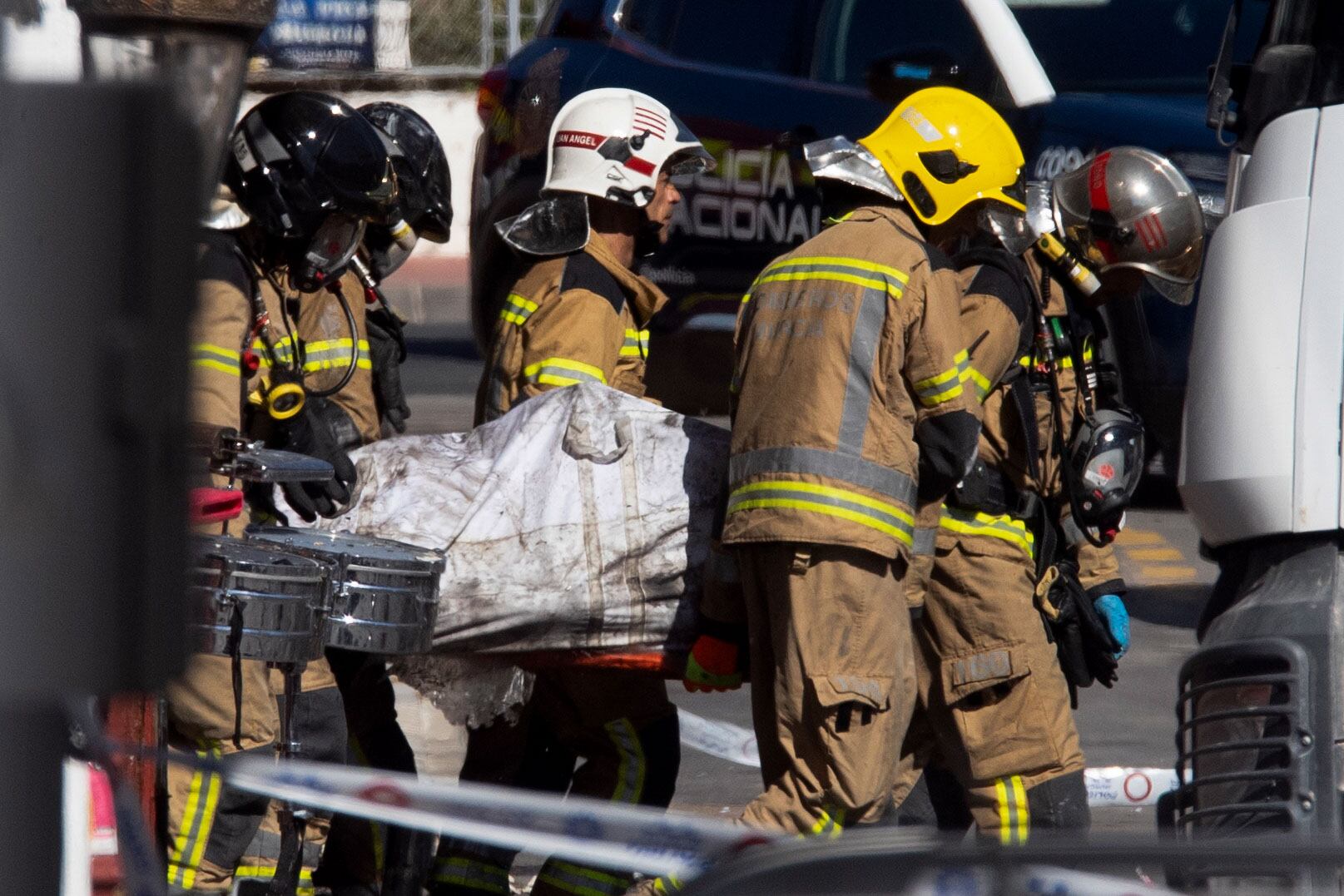 Bomberos trasladan el cuerpo de un fallecido en el incendio este domingo. EFE/ Marcial Guillén