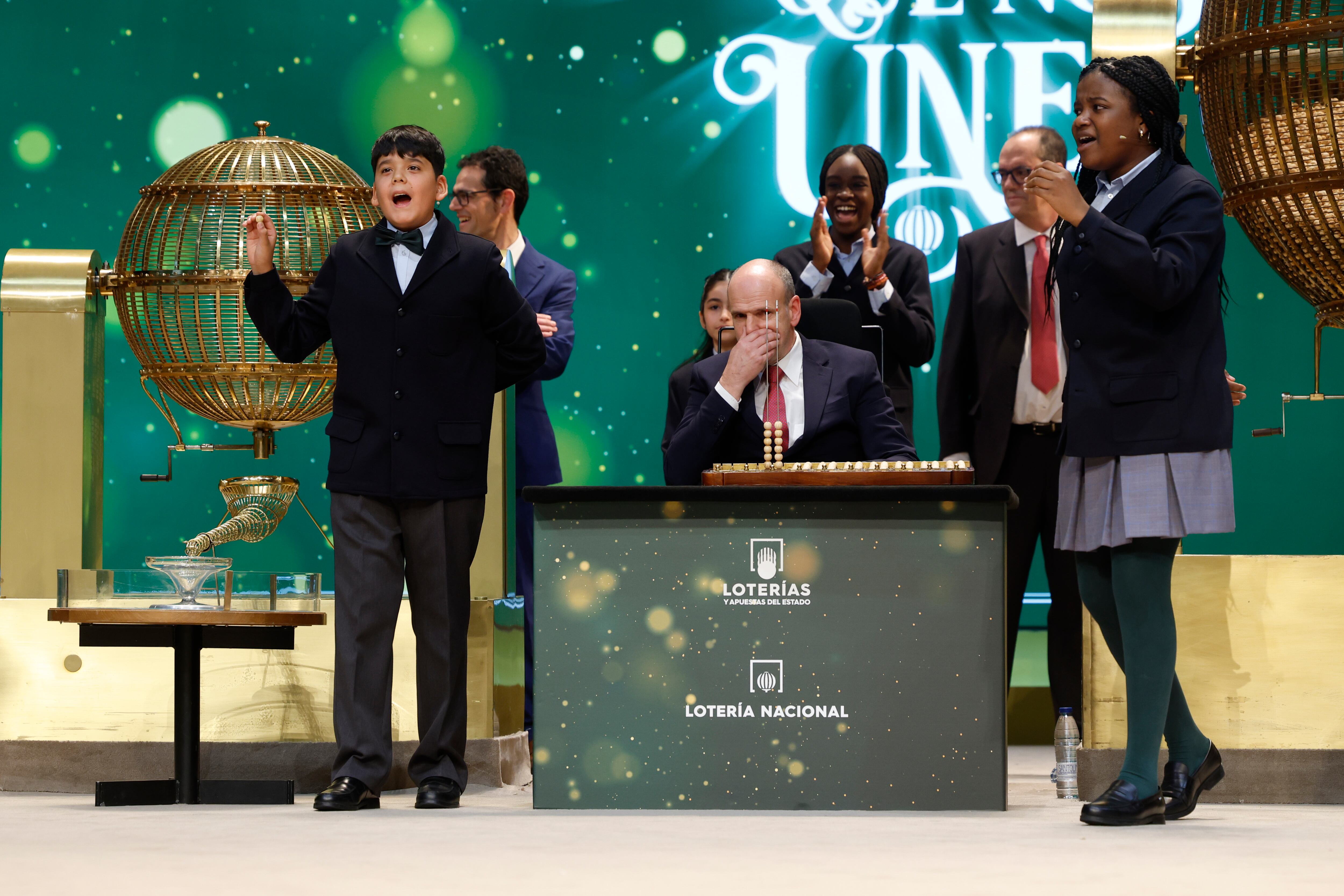 MADRID, 22/12/2023.- Yesica Paola Valencia Gómez y Francisco Moreno Durán cantan el gordo, y extraído por Elisabeth Obarisiagbon Iyamu y Rosario Martínez García, que este año ha recaído en el número 88.008, durante el sorteo extraordinario de Navidad de la Lotería Nacional este viernes en el Teatro Real de Madrid. EFE/ J.J. Guillén