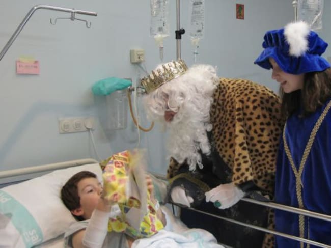 El Rey Melchor, entregando regalos a uno de los niños hospitalizados