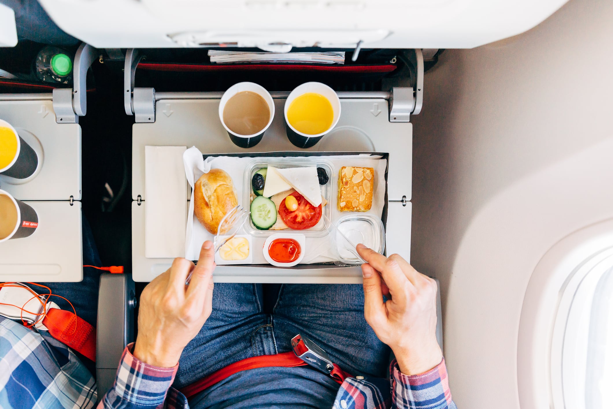 Una persona comiendo en el avión.