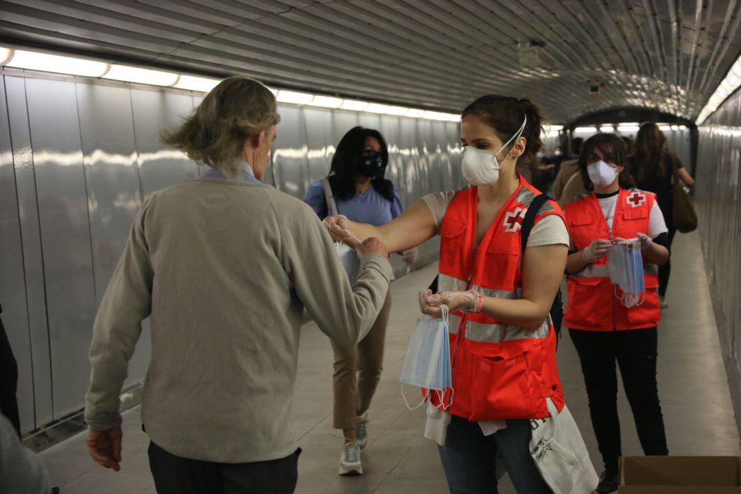 Voluntàries de la Creu Roja reparteixen mascaretes al metro de Barcelona 