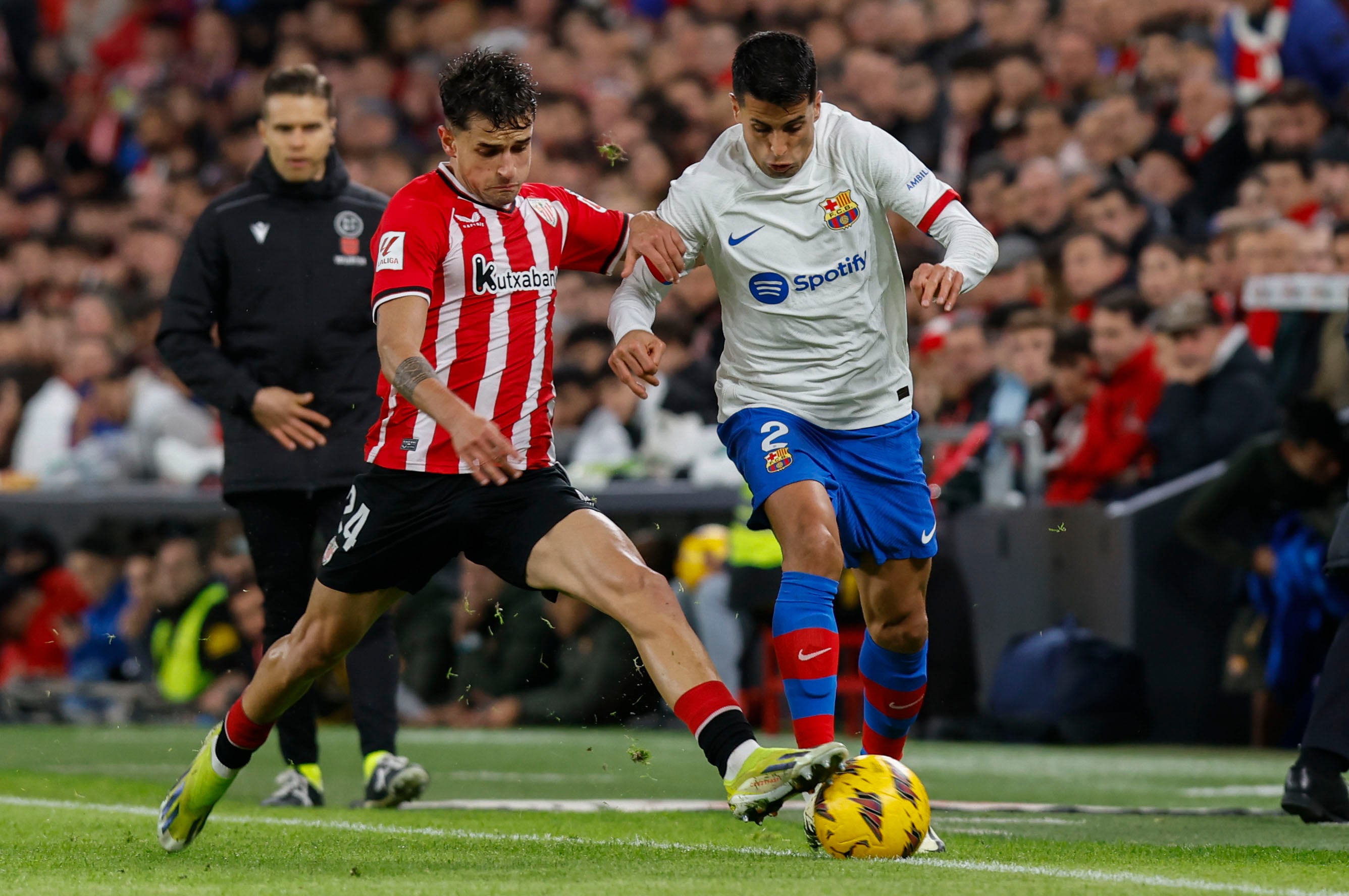 El defensa del Athletic Club Beñat Prados (i) lucha un balón con el defensa portugués del FC Barcelona João Cancelo, durante el partido de Liga de Primera División que el Athletic Club y el FC Barcelona disputan este domingo en el estadio de San Mamés