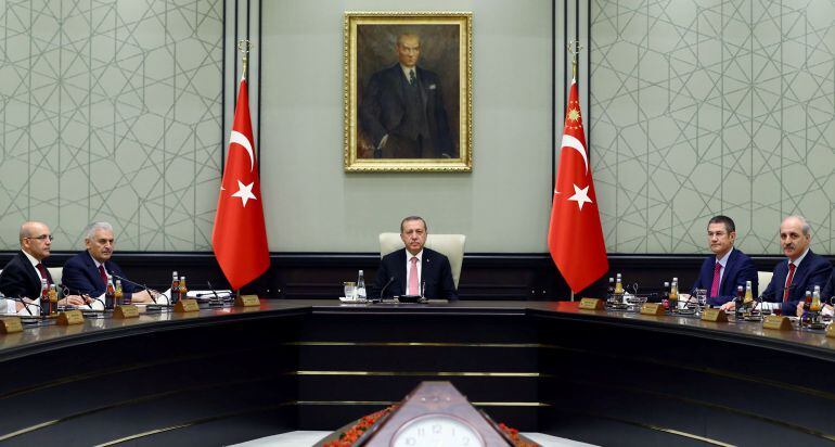 El presidente turco Tayyip Erdogan, flanqueado por  Mehmet Simsek (L), Numan Kurtulmus (R) y Nurettin Canikli 