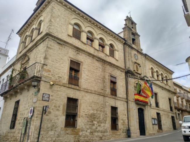 Fachada del ayuntamiento de Villacarrillo con dos banderas nacionales en el balcón principal, correspondiente a la alcaldía.