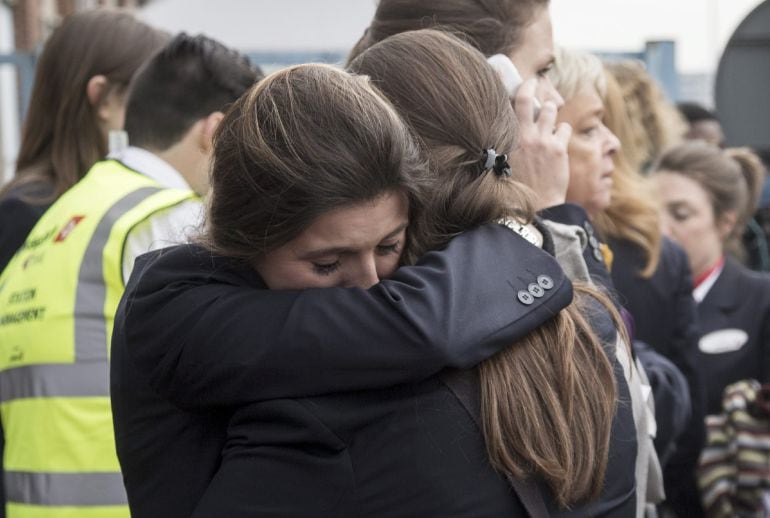 Dos trabajadoras del aeropuerto se abrazan mientras son evacuadas junto a los pasajeros de la zona aeroportuaria tras registrarse explosiones en el aeropuerto internacional de Zaventem.