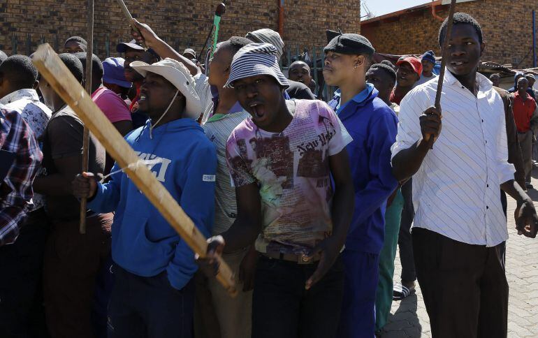 Varios jóvenes sudafricanos bailan y cantan para pedir a los dueños de negocios de origen extranjero que abandonen la zona 