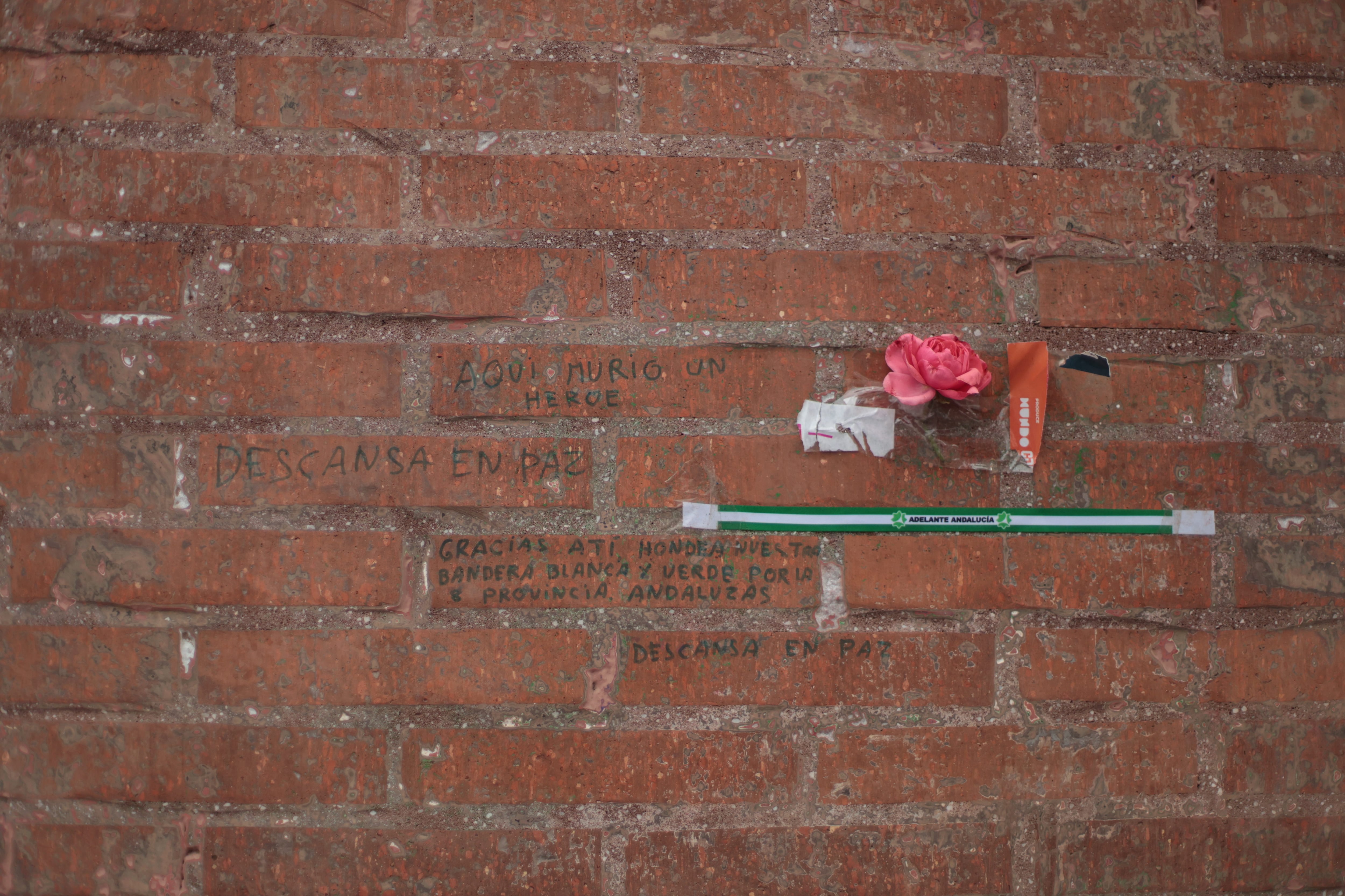 La pared de la esquina en la que murió Caparrós con un clavel e inscripciones en recuerdo del joven
