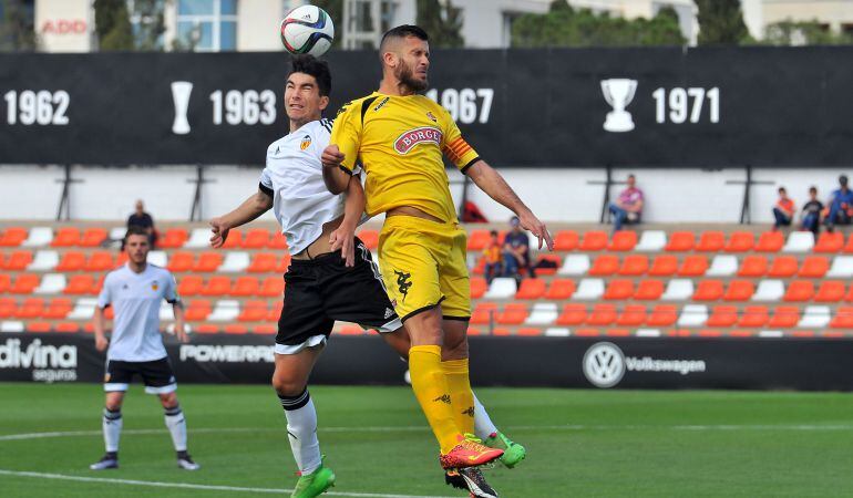 Alex Colorado disputa una pilota amb un jugador del Valencia Mestalla.
