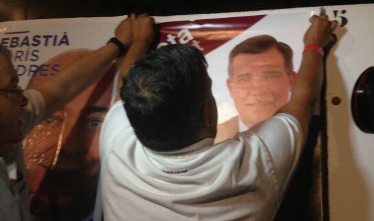 Jordi Cervera, penjant el cartell electoral d'ARA Reus.