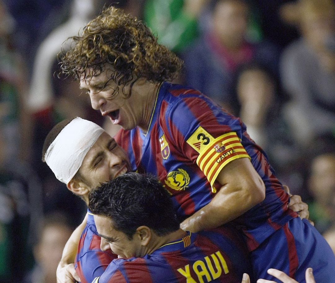 Puyol, Piqué y Xavi celebran un gol