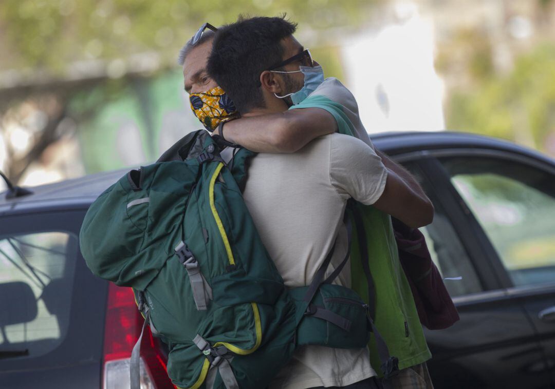 Dos personas se abrazan este viernes en Sevilla capital.