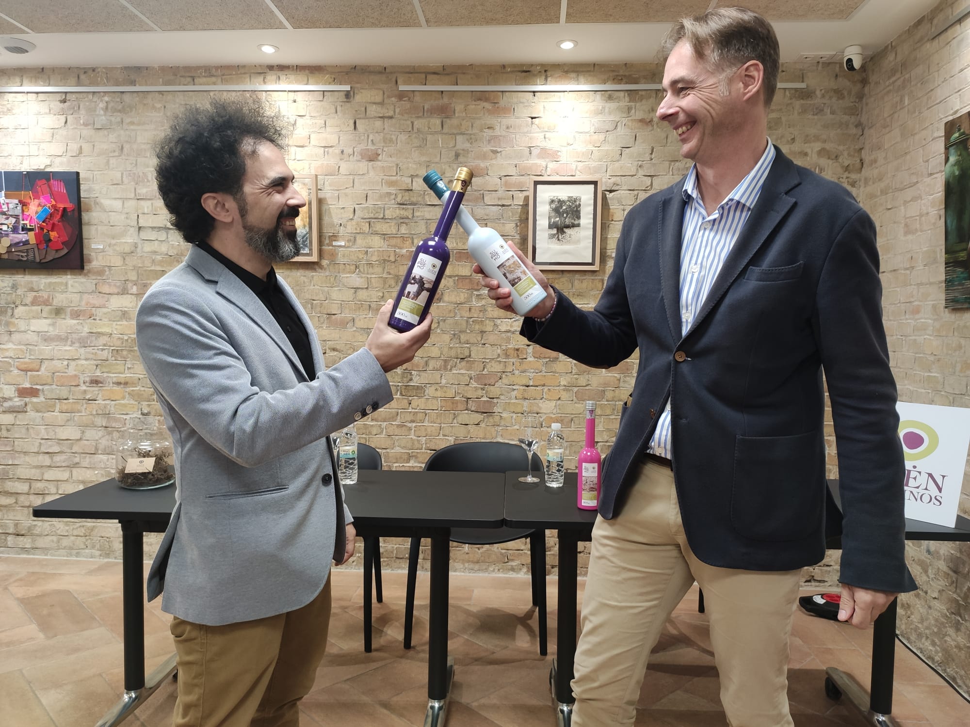 David Hernández, de Jaén de Vinos, y Alberto Molinero, de Aceite Supremo, chocan dos botellas de la cosecha de este año