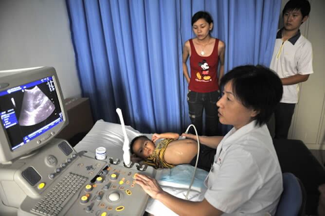 Una doctora china examina a un bebé afectado por la leche contaminada