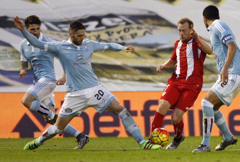 El defensa del Celta de Vigo Sergi Gómez con el balón ante el centrocampista del Sevilla Michael Krohn-Dehli