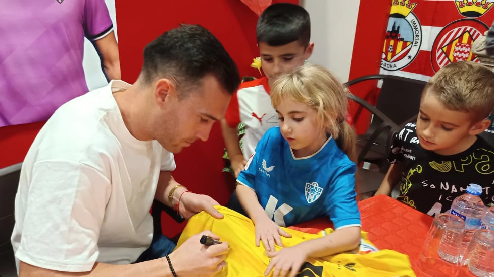 Fernando firmando la camiseta a Martina en el aniversario de la Peña Milhojas