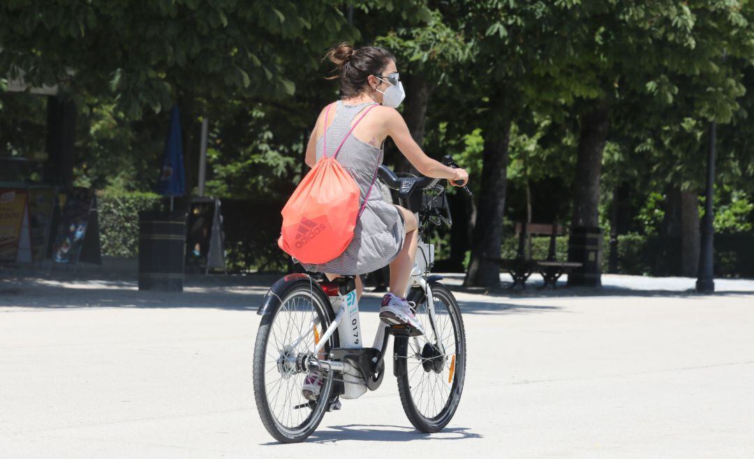 Una joven se desplaza en bicicleta por el Parque de El Retiro en Madrid.