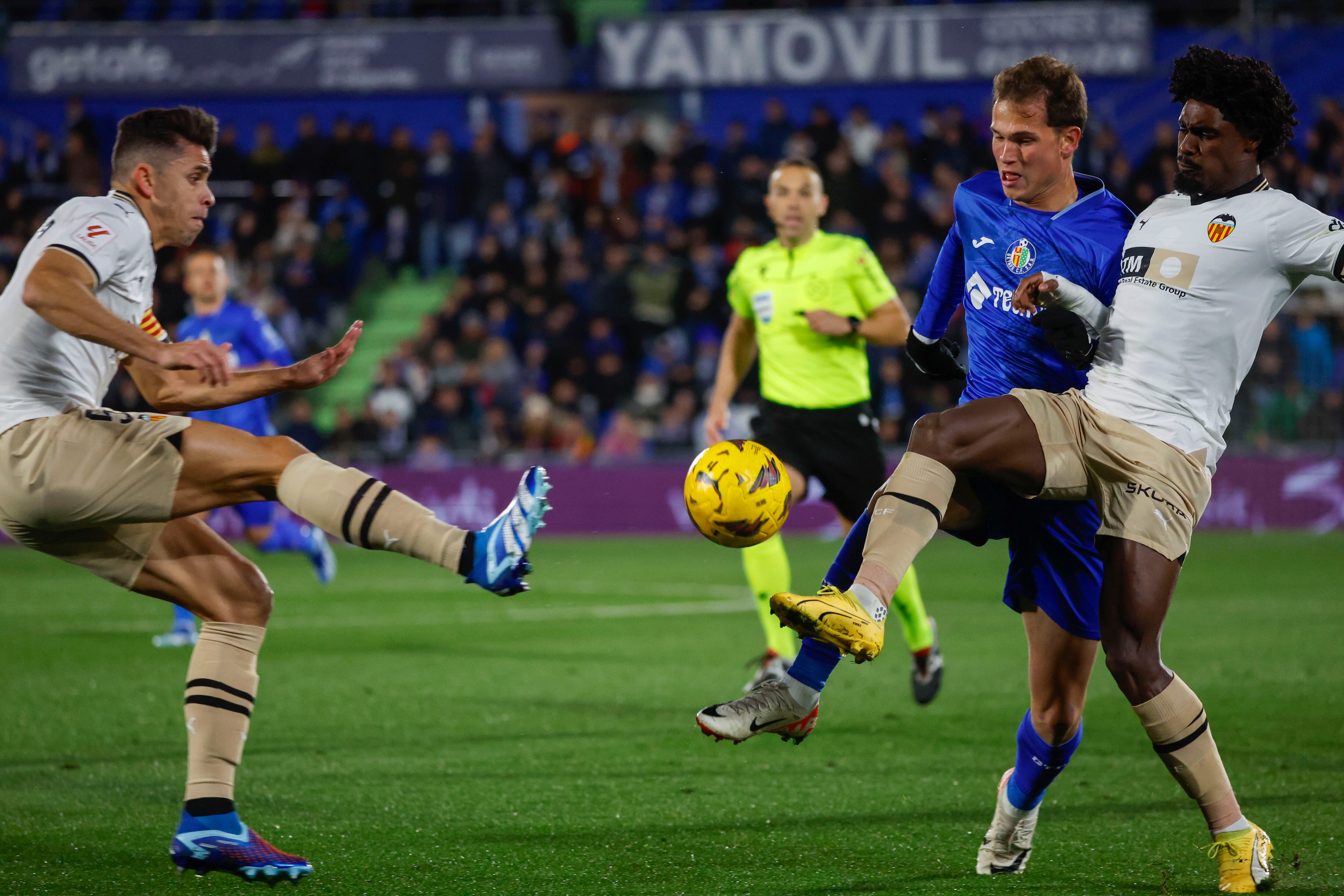 El delantero del Getafe, Latasa (c), disputa el balón ante los jugadores del Valencia, el portugués Thierry (d) y el brasileño Gabriel Paulista, durante el encuentro correspondiente a la jornada 16 de primera división que disputan hoy viernes Getafe y Valencia en el Coliseum de Getafe. EFE / Zipi Aragón.