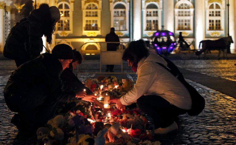 Varias personas depositan flores y velas en homenaje a las víctimas del accidente aéreo ocurrido el sábado pasado en Egipto