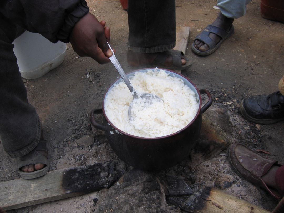 Personas migrantes en un asentamiento chavolista de Huelva cocinando