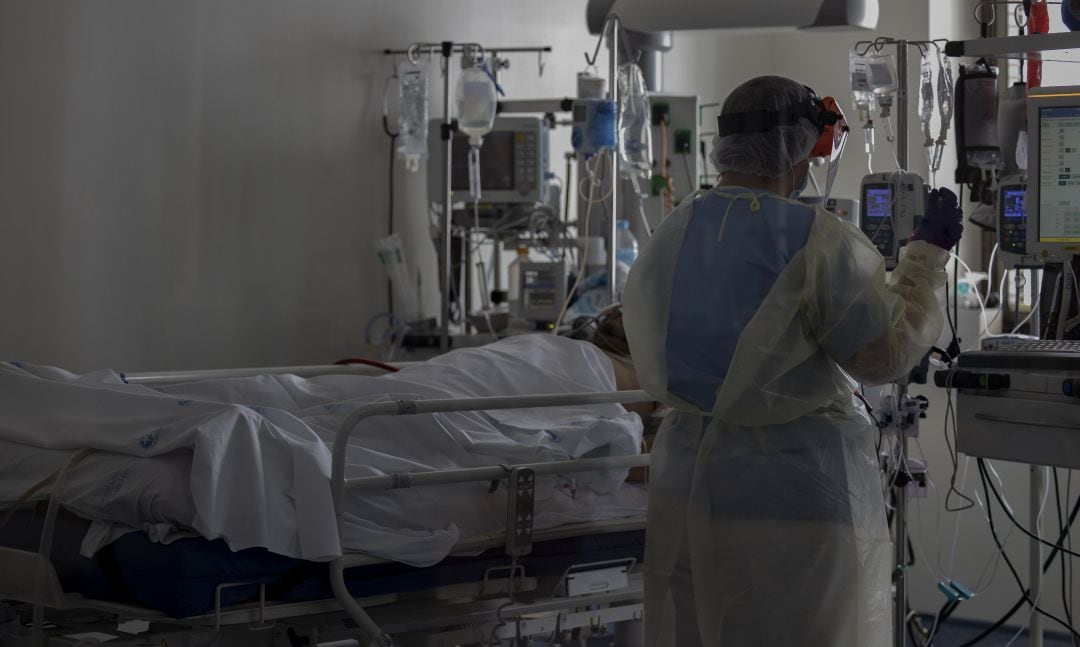 Una profesional sanitaria junto a un paciente.