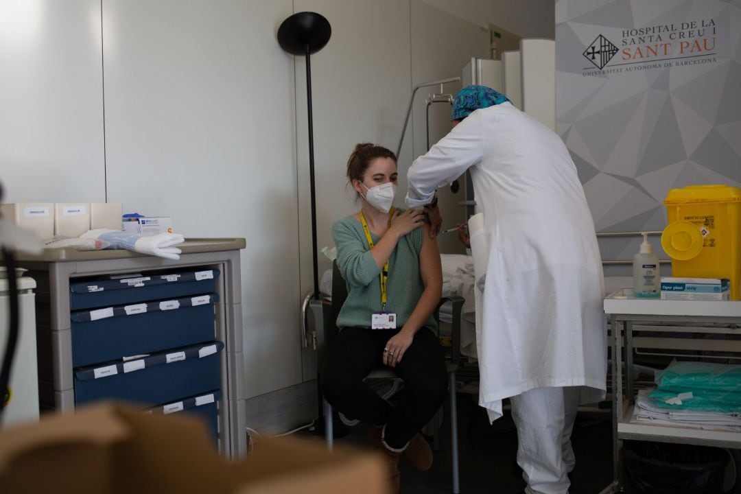 Una enfermera vacuna a un profesional sanitario con la vacuna de Pfizer-BioNtech contra el COVID-19