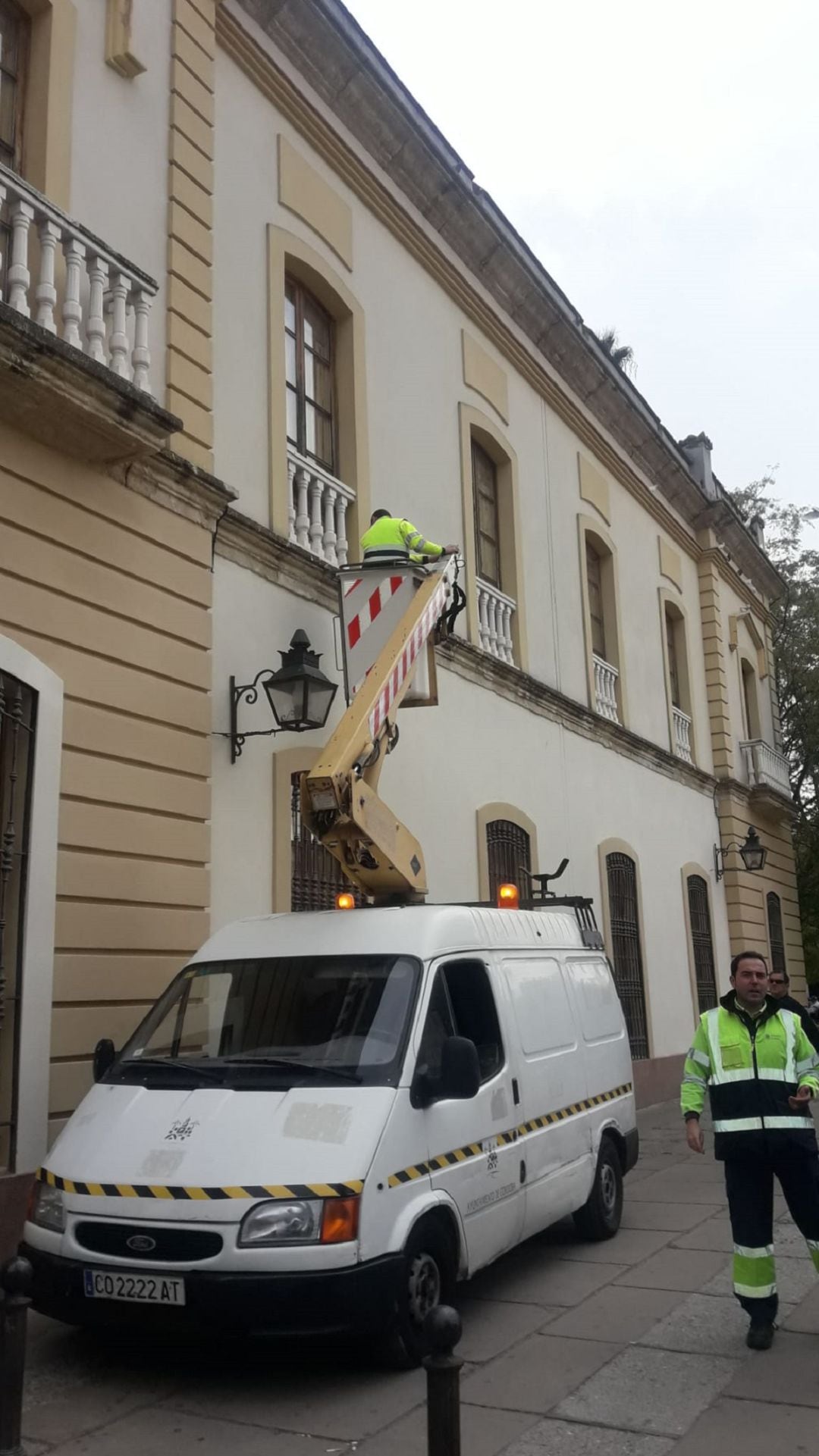 Operarios del área municipal de Infraestructuras retiran la simbología que Córdoba Solidaria y Ecologistas en Acción tenían colgada en sus balcones de la Casa Ciudadana