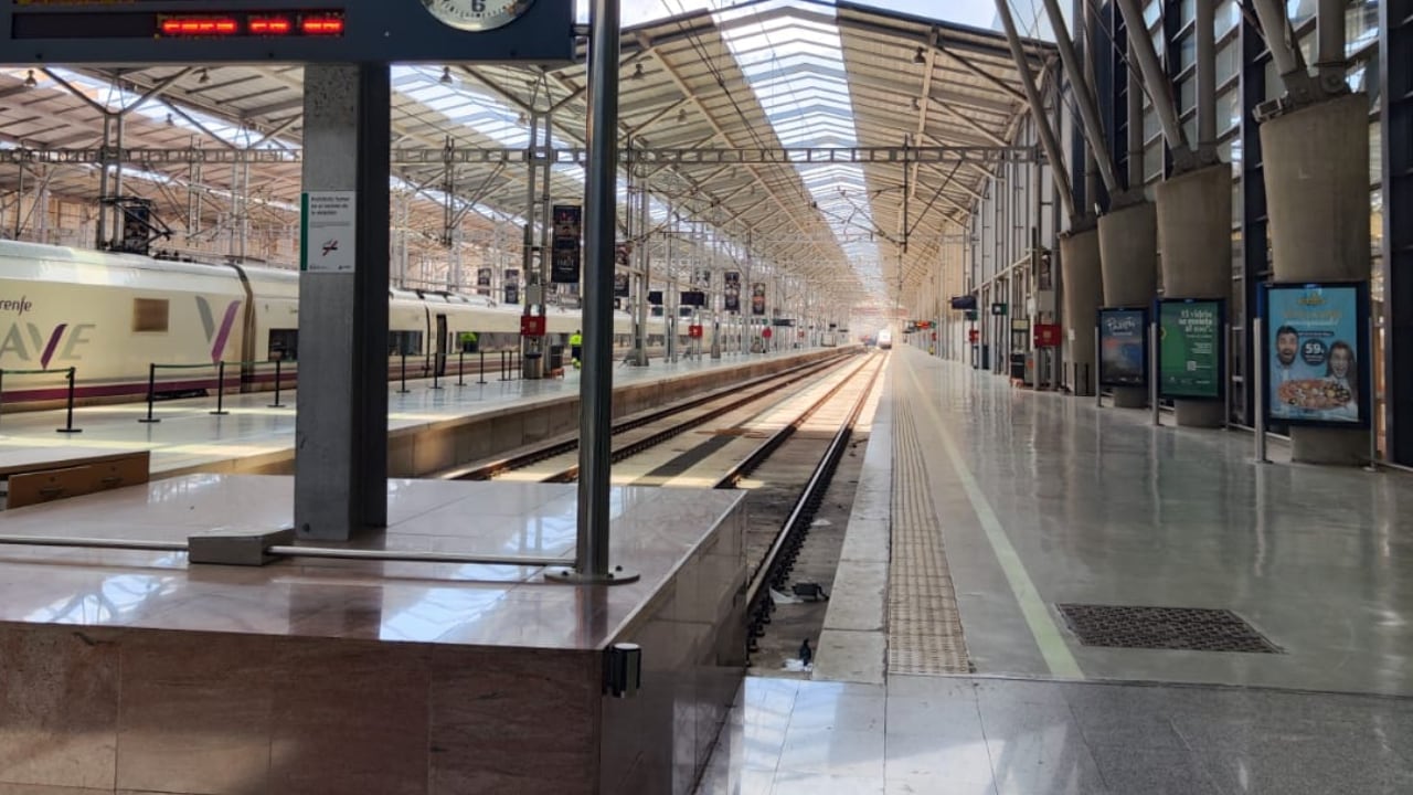 Tren AVANT procedente de Granada estacionado (en la lejanía) en la estación de Málaga lejos de la topera de la cabecera de la terminal, dejando espacio para el tren procedente de Sevilla