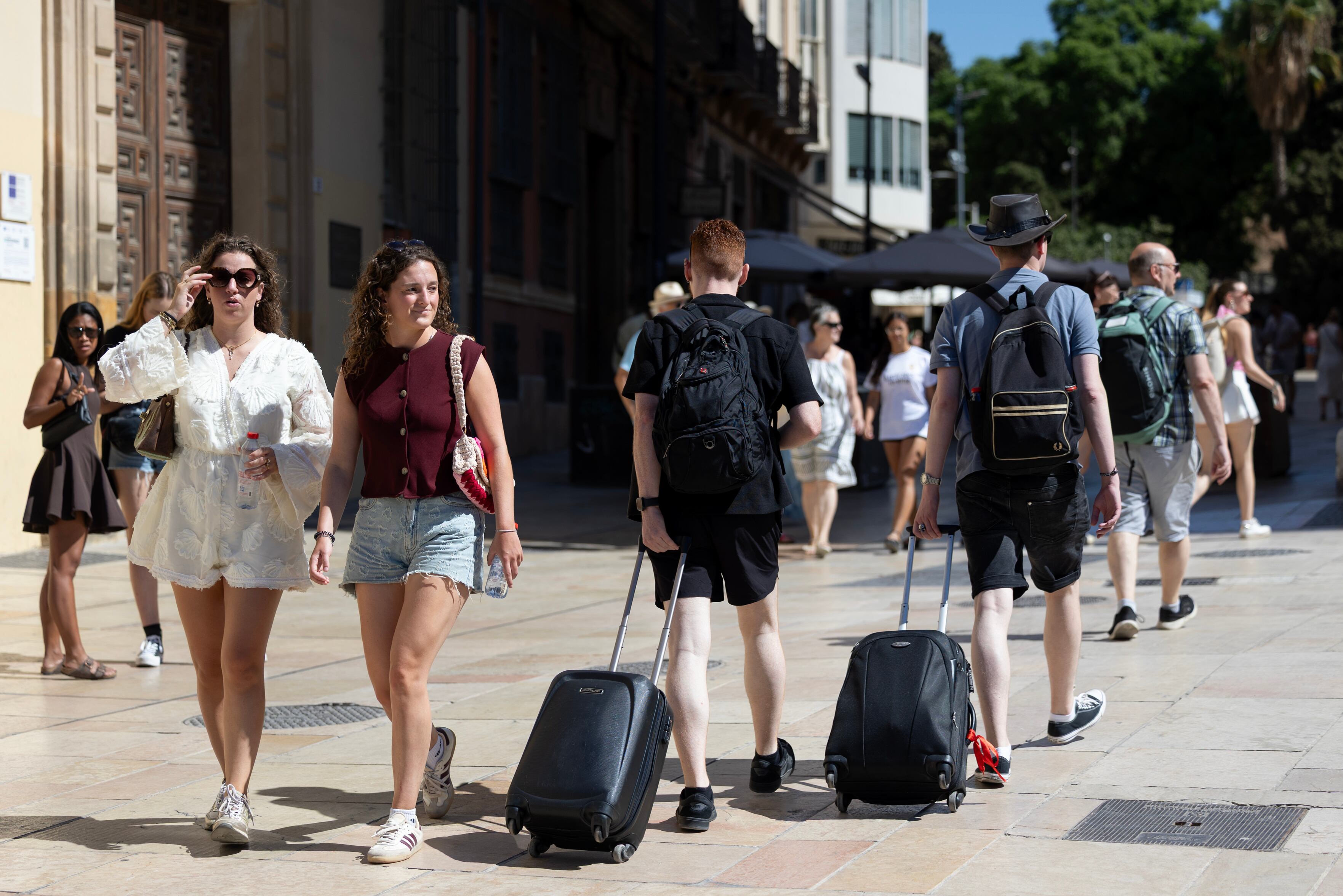 MÁLAGA, 31/08/2025.- Varios turistas arrastran maletas por el centro histórico de Málaga en el último día del mes de agosto. Meliá, RIU y Palladium apuntan a una temporada estival positiva, similar a la anterior, en la que esperan mejorar los ingresos de 2024 en España, pero con crecimientos más moderados, mientras Barceló asegura cumplir sus previsiones de un verano en niveles récord e incluso superarlas en muchos casos. EFE/ Daniel Pérez