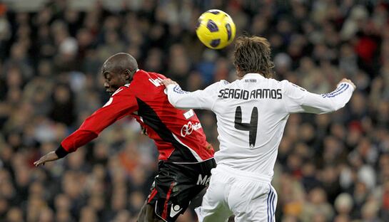 El defensa del Real Madrid Sergio Ramos (d) cabecea un balón ante el delantero camerunés del RCD Mallorca Pierre Webó durante el partido correspondiente a la vigésima jornada del Campeonato Nacional de Liga de Primera División que enfrenta esta tarde a am