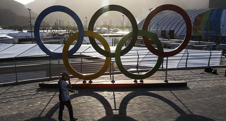 Un hombre pasa frente a los anillos olímpicos, dentro de la Villa Olímpica en la ciudad de Río de Janeiro (Brasil). 