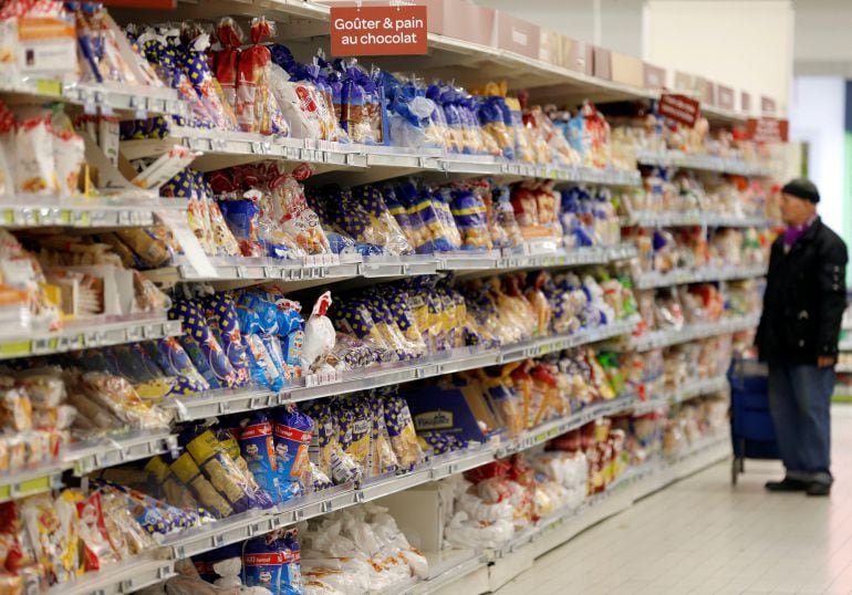 Un hombre busca alimentos ultraprocesados en un supermercado de París. 