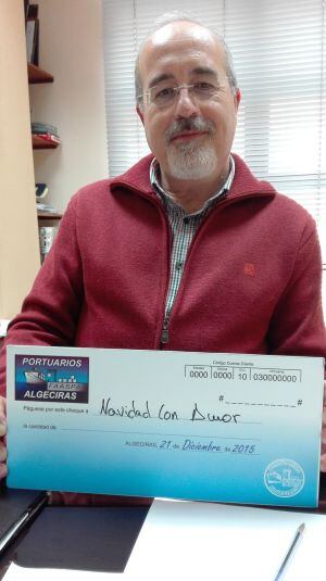El director de Radio Algeciras, Joaquín Guirval, posa con el cheque dirigido a Navidad con Amor por FAS Portuarios.