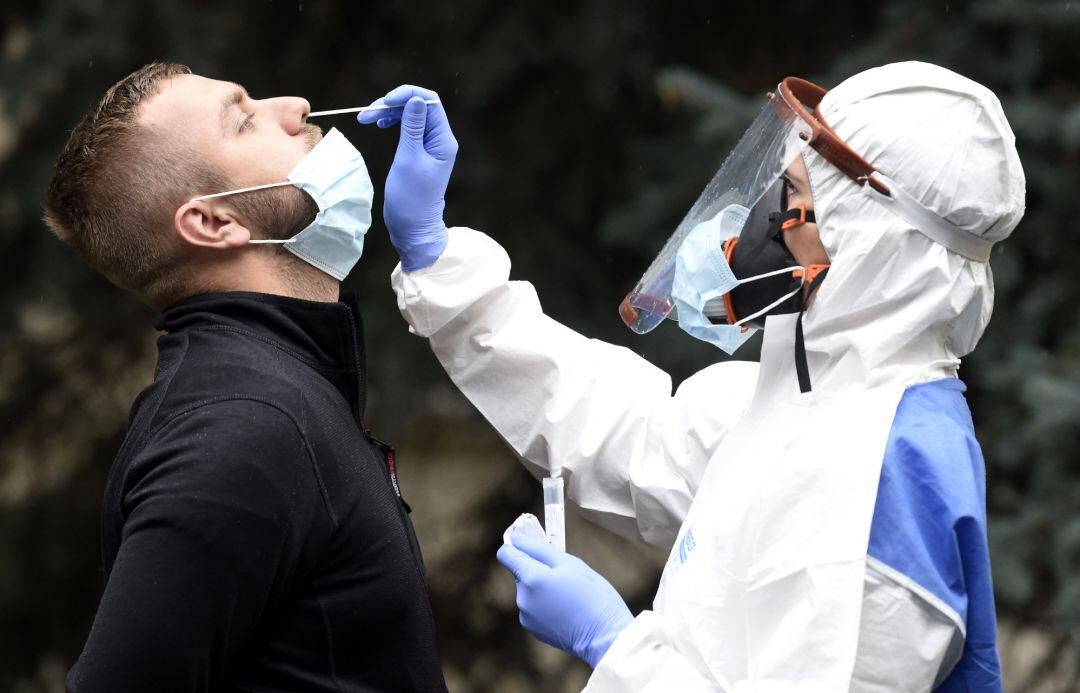 Una profesional sanitaria realiza una prueba de coronavirus a un hombre.