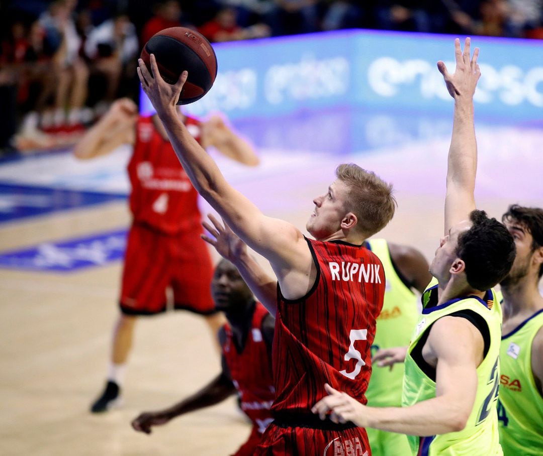 El base esloveno del Montakit Fuenlabrada Luka Rupnik (c), que anotó 15 puntos y fue el mejor de los locales, penetra a canasta ante la defensa de los jugadores del Barça Lassa.