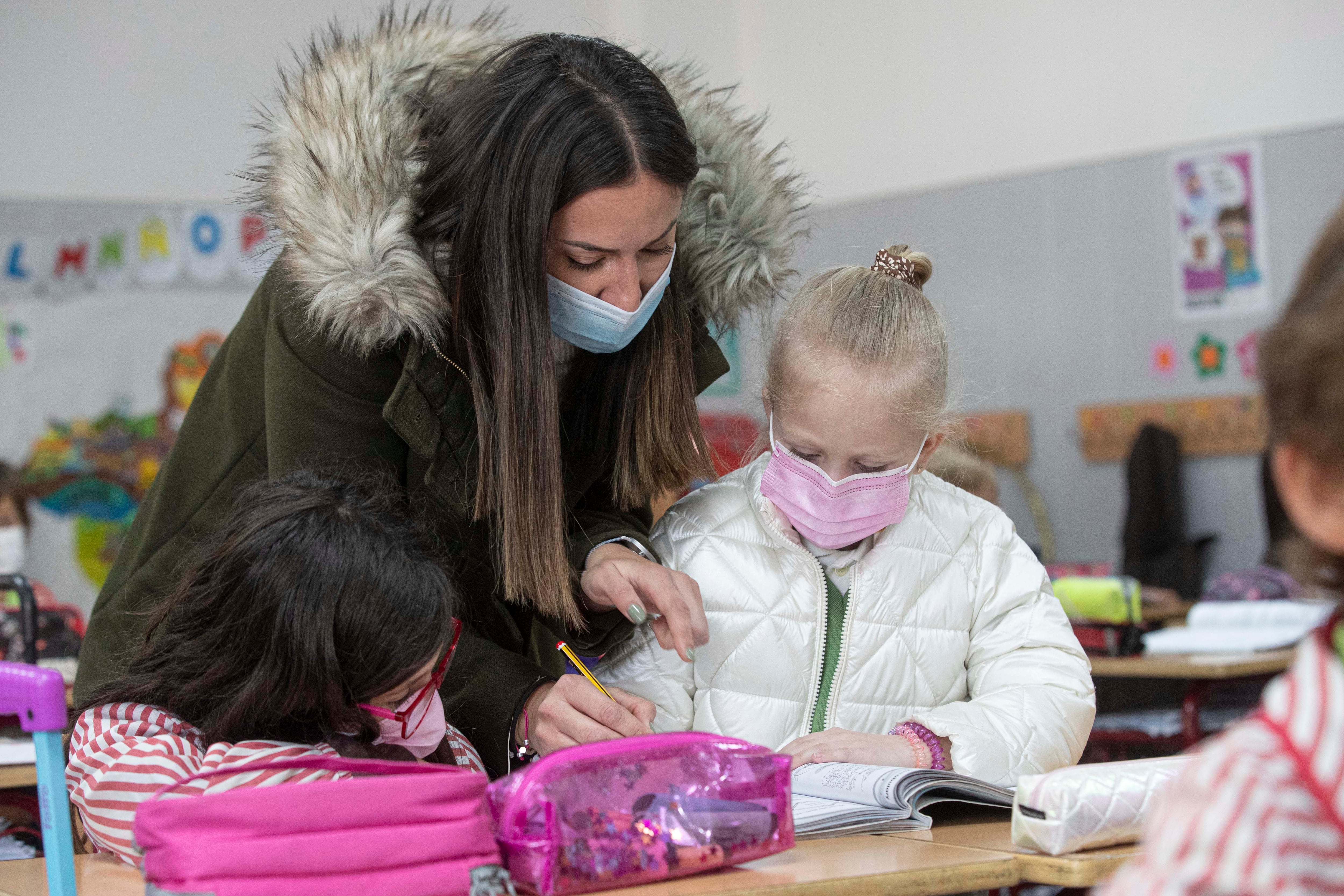 MOLINA DE SEGURA (MURCIA), 10/03/2022.- Una maestra de segudno de primaria del colegio Vistarreal de Molina de Segura, que ha escolarizado a cuatro niños ucranianos, de entre 4 y 15 años de edad, que huyeron de la invasión rusa a su país en compañía de sus madres, ayuda en clase a Annia de siete años, una de las niñas escolarizadas, este jueves en el colegio. EFE/Marcial Guillén
