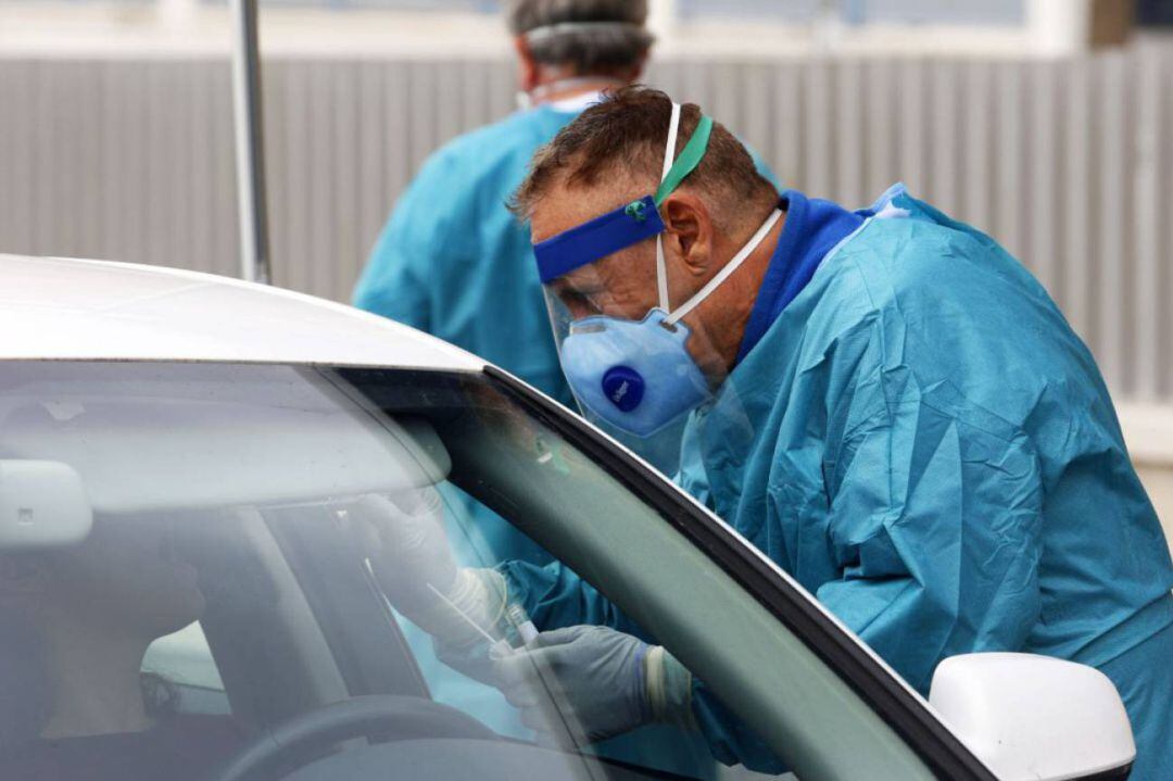 Dispositivo sanitario de la prueba test del PCR para detectar la infección por coronavirus a las personas desde su coche, instalado en el recinto de aparcamiento del centro de salud de la barriada La Roca, en Málaga