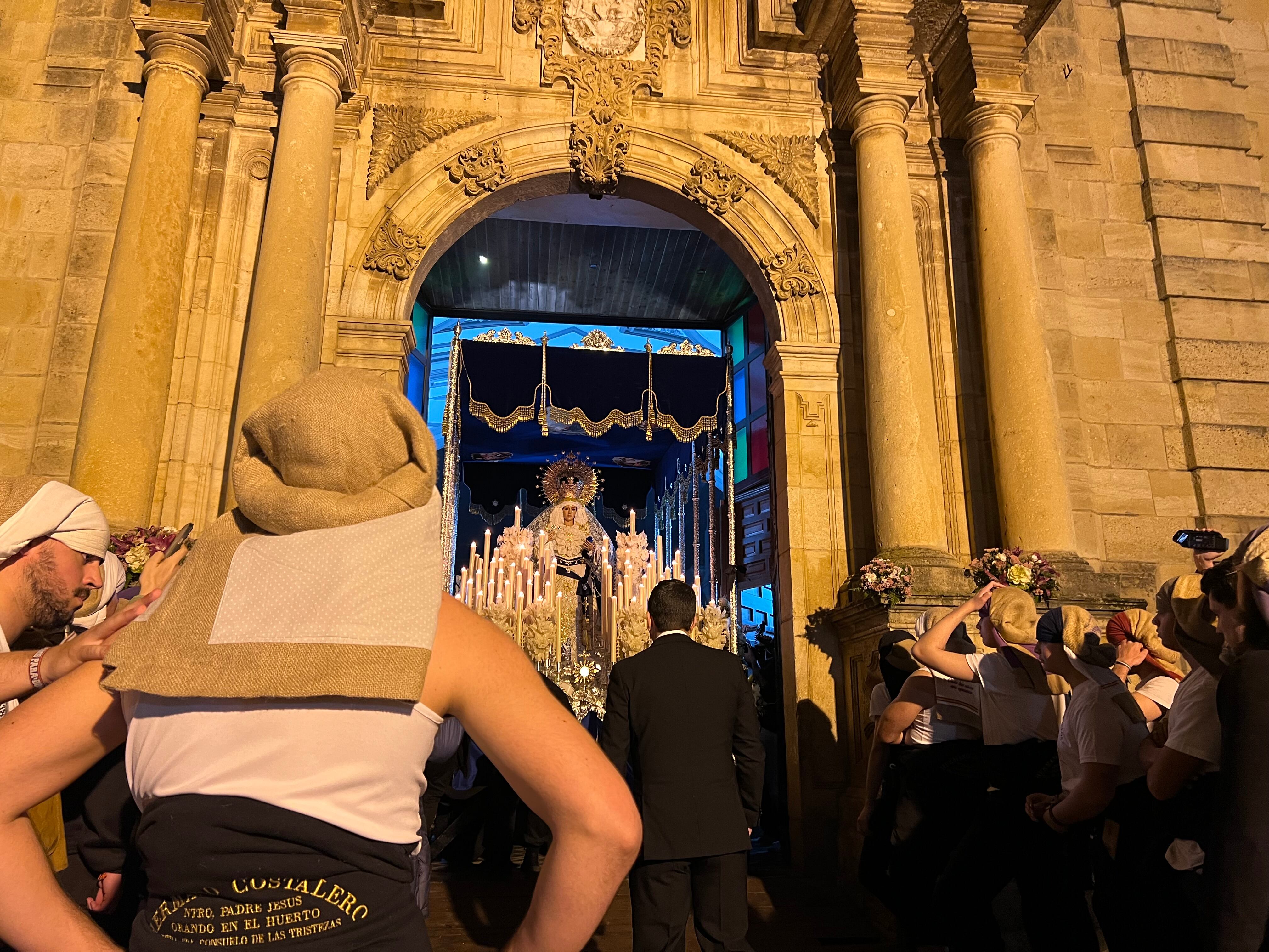 Los costaleros y el capataz de Consuelo de las Tristezas realizan las labores de salida de la parroquia de Santa Cecilia