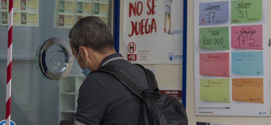 Una persona compra lotería en una administración