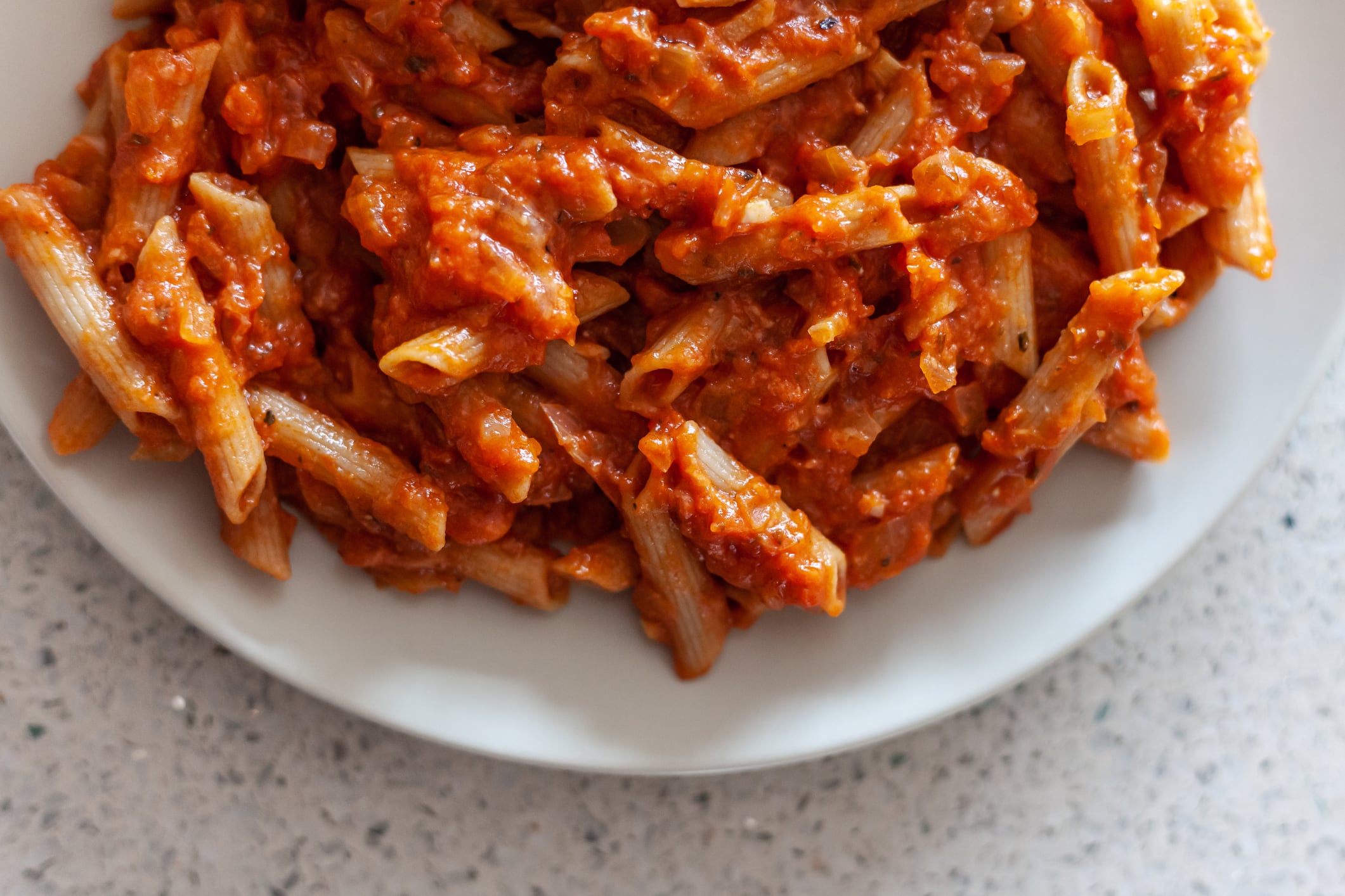 Un plato casero de macarrones con tomate.