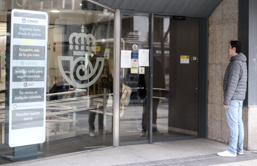 Una persona frente a una oficina de Correos.