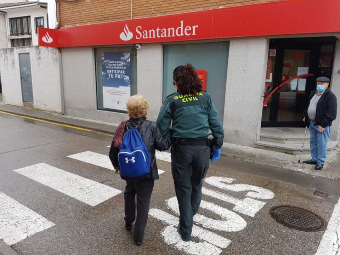 Una agente ayuda a una anciana