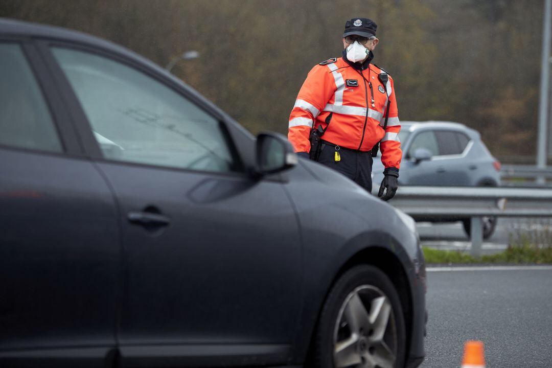 Un agente de la Ertzaintza vigilan a los vehículos que circulan por la AP-8, después del Peaje de Iurreta