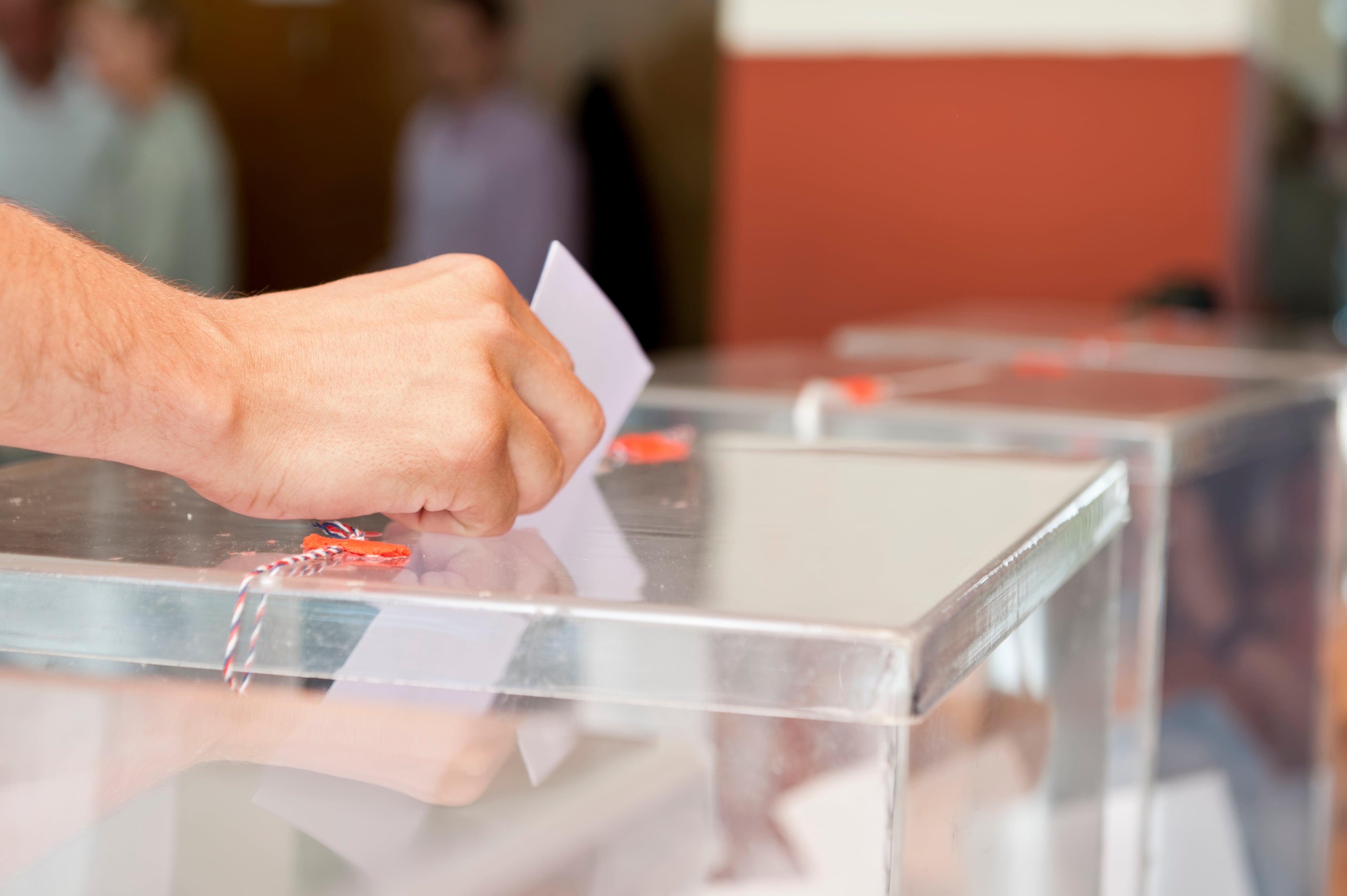 Un hombre introduce un voto en una urna electoral