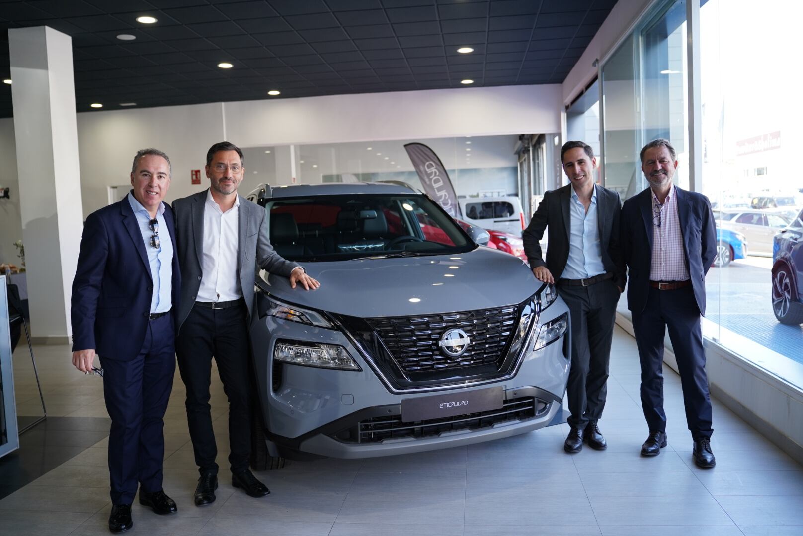 Los CEO de Nissan en España Christian Costaganna y de TOKIO Motor, Antonio Gil, a un lado y al otro de un vehículo Nissan durante la inauguración del concesionario.