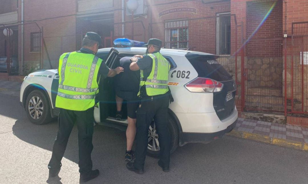 El hombre es introducido es el coche de la Guardia Civil tras entregarse. 