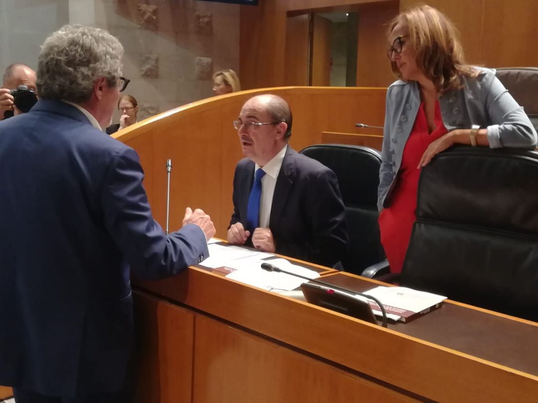 El presidente de Aragón, Javier Lambán, antes del inicio de la sesión de las Cortes de Aragón, junto a la consejera de Educación, Mayte Pérez, hablando con Gregorio Briz, de CHA